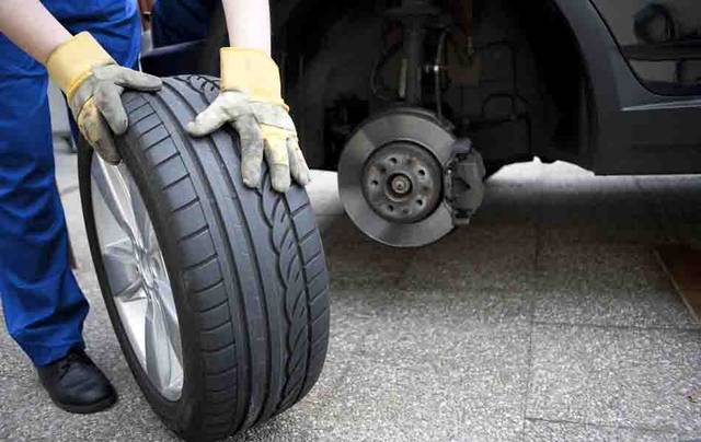 Mechanic inspecting a tyre on a car